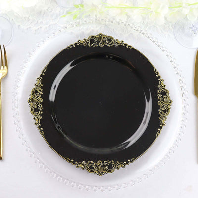 Black decorative plate with gold accents on a clear charger.