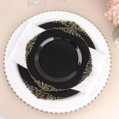 Elegant black and gold dinner plate set with white napkin on decorative charger plate.
