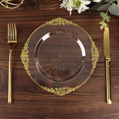 Elegant clear plate with gold trim, styled with gold cutlery on a wooden table.