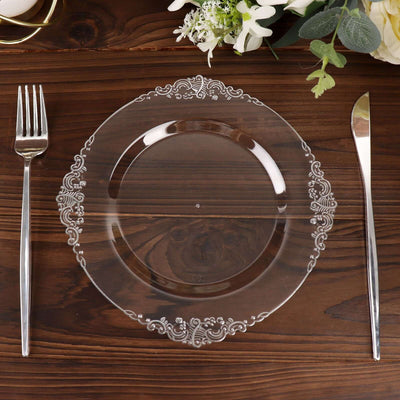 Elegant clear decorative plate with ornate rim on wooden table setting.