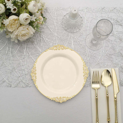 Elegant white plate with gold trim, surrounded by silver cutlery and floral centerpiece.