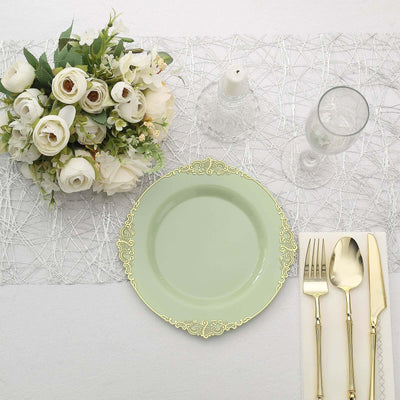Elegant table setting with a mint green plate, silver cutlery, and white floral arrangement.