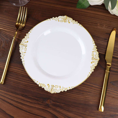 Elegant white plate with gold floral design, accompanied by gold cutlery.