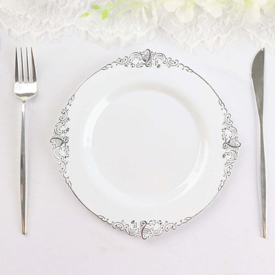 Elegant white plate with silver trim, fork, and knife on a lace table setting.