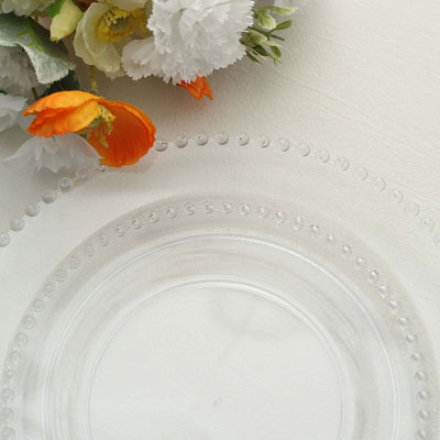 Clear decorative plate with beaded edge and floral accents.