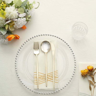 Elegant table setting with gold utensils and floral decor.