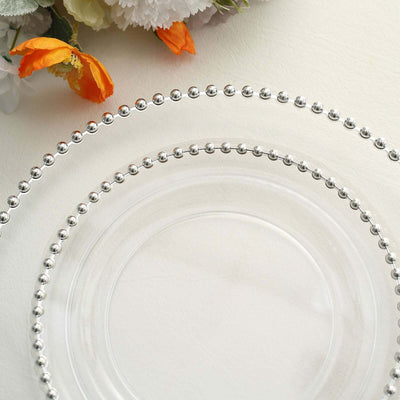 Clear glass plates with beaded edges, elegantly arranged with floral accents.