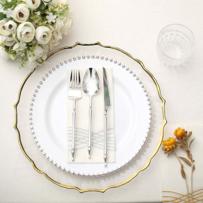 Elegant table setting with silver cutlery on a decorative plate.