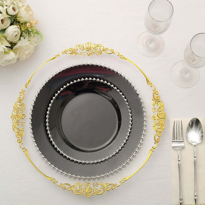 Elegant black dinner plates with gold accents, arranged with cutlery and glasses.