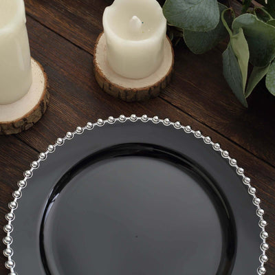 Elegant black plate with beaded silver rim, styled with candles and greenery.