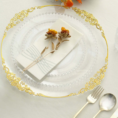 Elegant clear glass plate with gold accents, featuring a napkin and dried flowers.