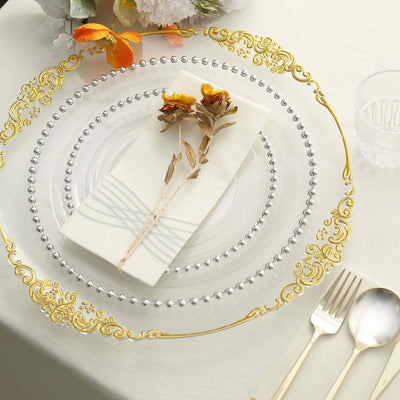 Elegant glass plate with gold and silver detailing, adorned with a floral napkin.