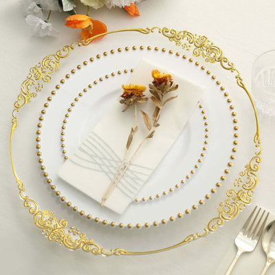 Elegant gold-trimmed dinner plate with napkin and dried flowers arrangement.