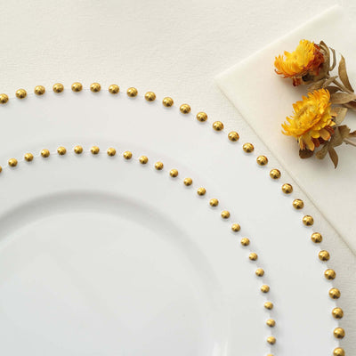 Elegant white plate with gold beaded rim and dried flowers