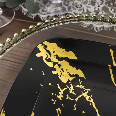 Black plate with gold abstract design on a wooden table.