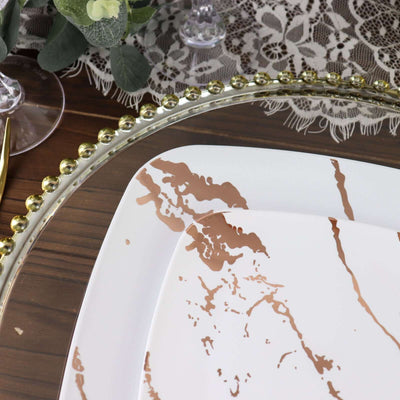 Elegant white plate with rose gold marble design on wooden table.