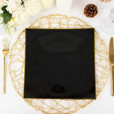 Elegant black square plate on a decorative gold charger with cutlery.
