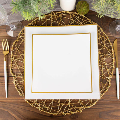 Elegant white dinner plate with gold trim on a decorative gold charger.