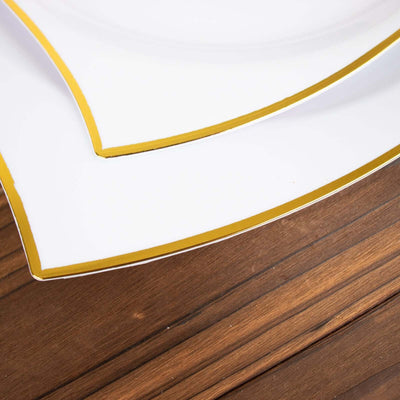 Elegant white plates with gold trim on a wooden surface.