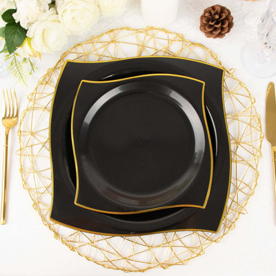 Elegant black dinnerware set with gold trim on a decorative gold charger.