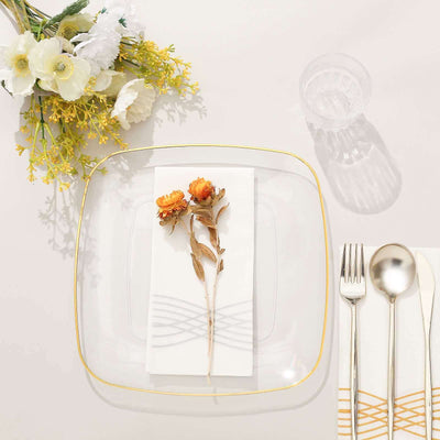 Elegant clear plate set with floral decoration and utensils on a neutral table setting.