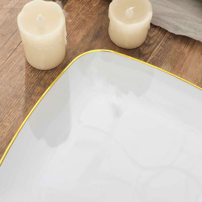 Elegant white plate with gold trim, surrounded by candles.