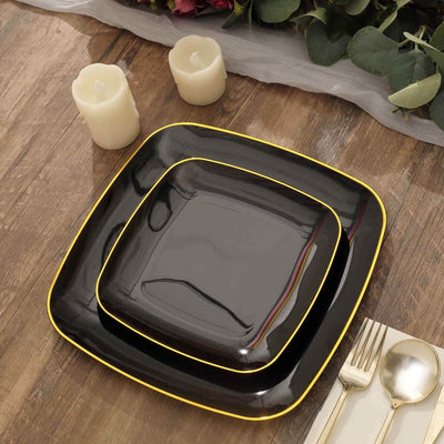 Black dinner plates with yellow trim on a wooden table.