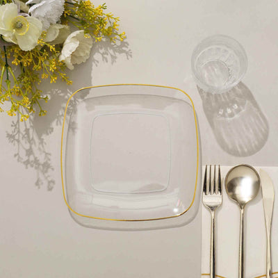 Clear square plate with gold rim, accompanied by cutlery and glass.
