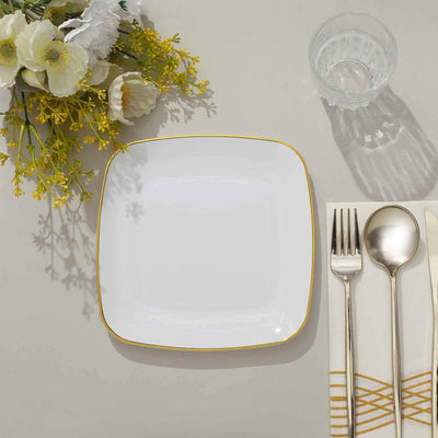 Elegant white plate with gold trim, accompanied by silver cutlery and glass.