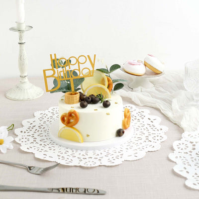 Birthday cake with fruit and decorative topper on a lace doily.