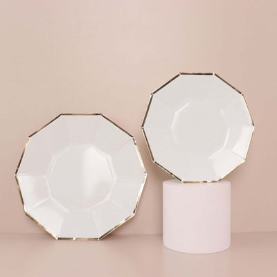 Elegant white plates with gold trim displayed on a pedestal.