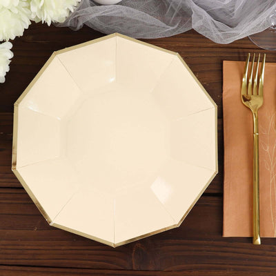Elegant octagonal cream plate with gold trim on wooden table