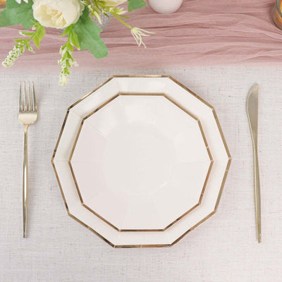Elegant octagonal white plate with gold trim on a textured table setting.