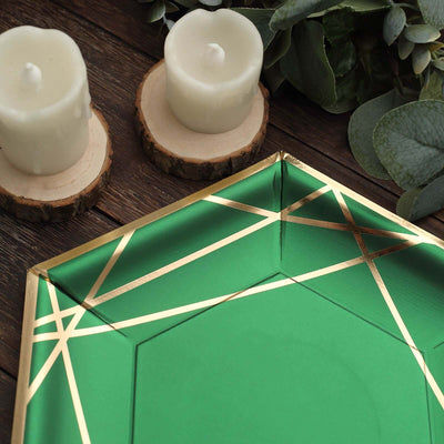 Green decorative plate with gold geometric design, styled with candles and foliage.