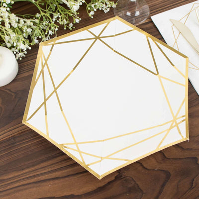 Hexagon-shaped white plate with gold geometric design on a wooden table.