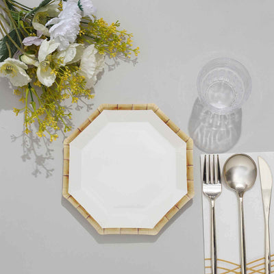 Octagonal white plate with bamboo design, silver cutlery, and a clear glass.