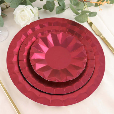 Red metallic paper plates in three sizes arranged for a festive table setting.