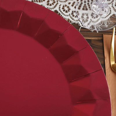 Red decorative plate with a scalloped edge on a wooden table.