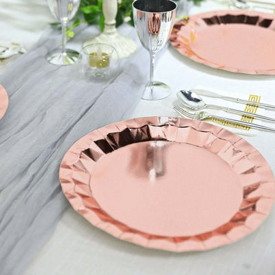 Rose gold disposable plates on a stylish table setting with cutlery and glassware.