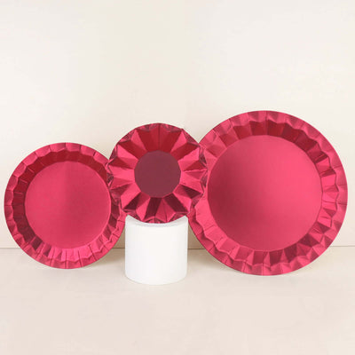 Set of three pink paper plates in varying sizes on a plain backdrop.