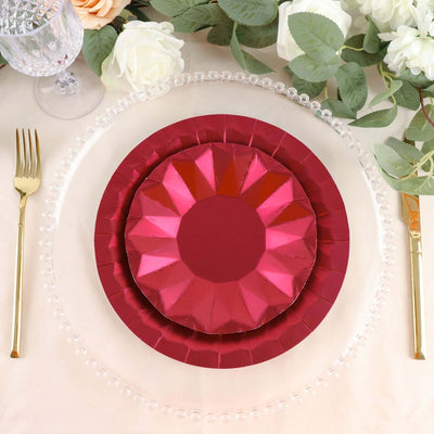Elegant red and pink paper plates layered on a decorative table setting.