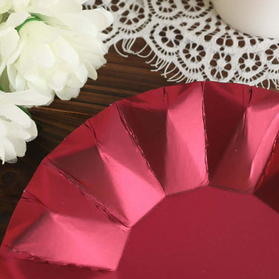 Red paper plate with scalloped edges on a wooden table.
