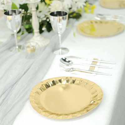Gold disposable plate on an elegant dining table setting with silverware and decor.