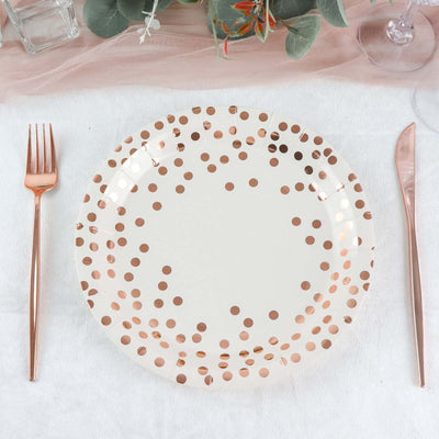 Rose gold polka dot plate with cutlery on a table setting.