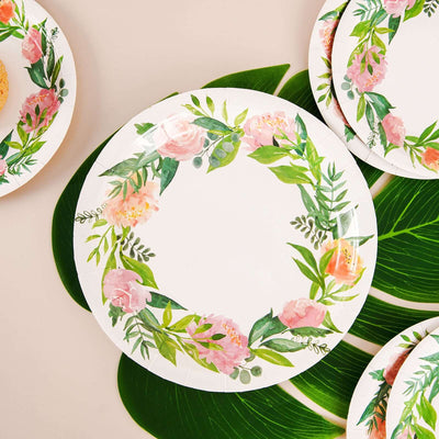 Floral design paper plates on green leaves, perfect for parties and events.
