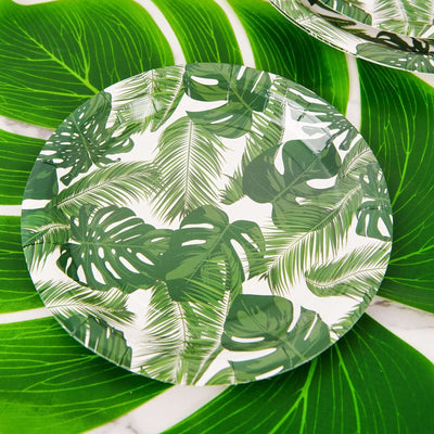 Green tropical leaf patterned plate on leafy background.