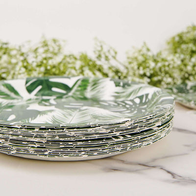 Stack of tropical leaf-patterned plates on a marble surface.