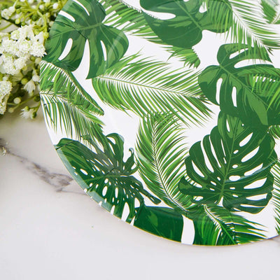 Green tropical leaf decorative plate on a marble surface.