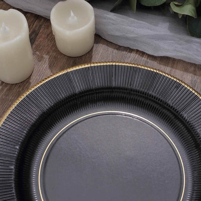 Elegant black plate with gold trim, surrounded by white candles and greenery.