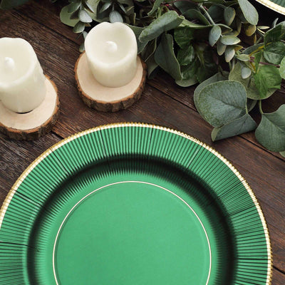 Green decorative plate on wooden table with candles and greenery.